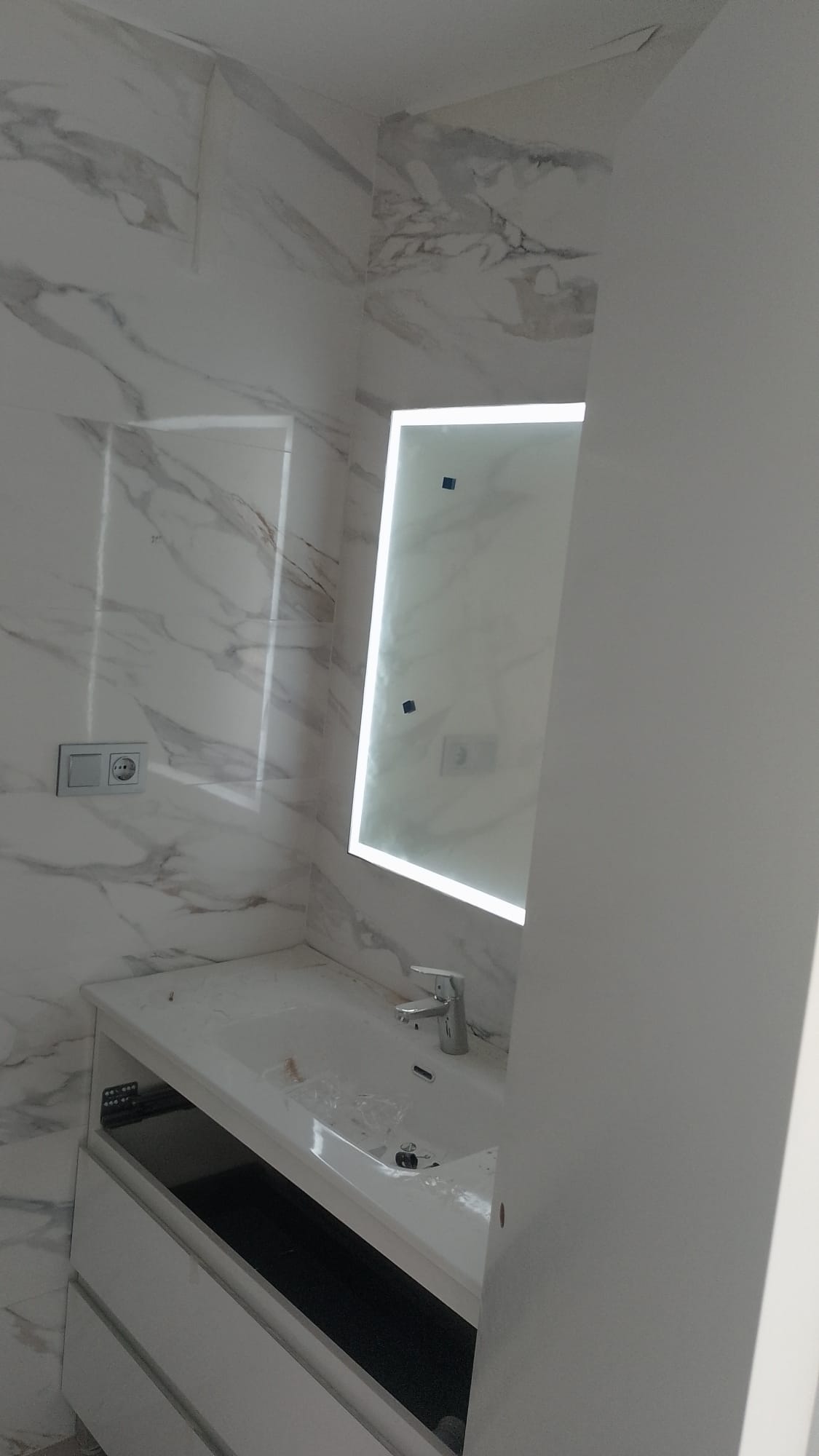 Reforma baño mármol con espejo LED